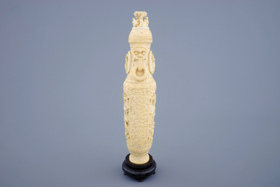 A Chinese carved ivory vase and cover on a wooden base, early 20th C.