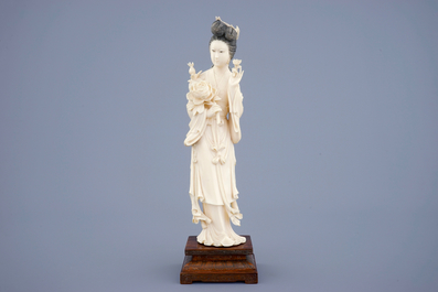 Een grote Chinese ivoren figuur van Guanyin op houten sokkel, begin 20e eeuw