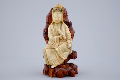 Une figure de Guanyin en pierre de savon sur socle en bois sculpt&eacute;, 18/19&egrave;me