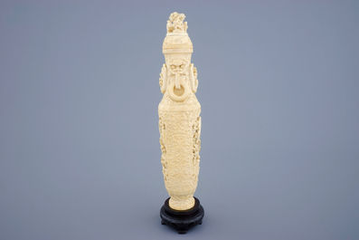 A Chinese carved ivory vase and cover on a wooden base, early 20th C.