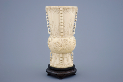 Un vase en ivoire sculpt&eacute; d'apr&egrave;s un mod&egrave;le archa&iuml;que sur socle en bois, 19&egrave;me