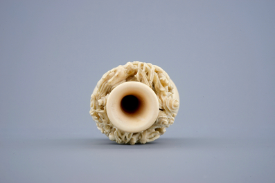 A Chinese carved ivory dragon vase on a wooden base, early 20th C.