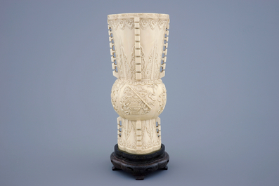 Un vase en ivoire sculpt&eacute; d'apr&egrave;s un mod&egrave;le archa&iuml;que sur socle en bois, 19&egrave;me