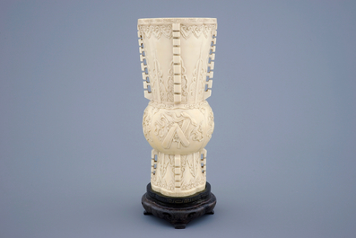 Un vase en ivoire sculpt&eacute; d'apr&egrave;s un mod&egrave;le archa&iuml;que sur socle en bois, 19&egrave;me