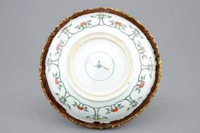 A Chinese famille verte plate with a gilt bronze mount, Kangxi