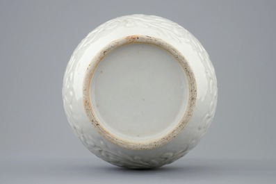 A relief-moulded blanc de Chine vase with flower scrolls, Kangxi