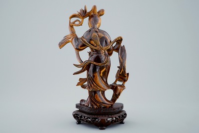Een Chinese gesculpteerd Guanyin in tijgeroog op houten basis, 19/20e eeuw