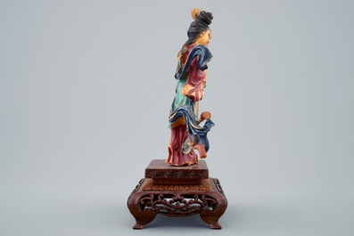 Une figure polychrome d'une beaut&eacute; aux fleurs en ivoire sculpt&eacute; sur socle en bois, d&eacute;but du 20&egrave;me
