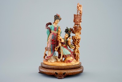 A Chinese polychrome carved ivory group on wooden base, 19th C.