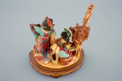 A Chinese polychrome carved ivory group on wooden base, 19th C.