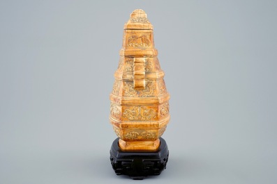 A Chinese parcel-gilt ivory vase and cover on wooden stand, 19th C.