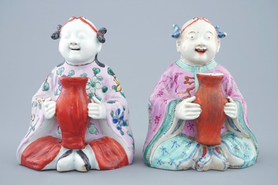 Een paar Chinese famille rose figuren van zittende jongens met een vaas, 18/19e eeuw