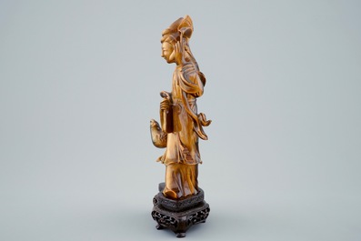 Een Chinese gesculpteerd Guanyin in tijgeroog op houten basis, 19/20e eeuw