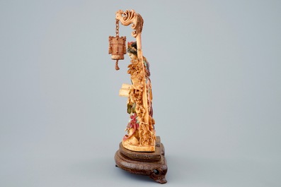 A Chinese polychrome carved ivory group on wooden base, 19th C.