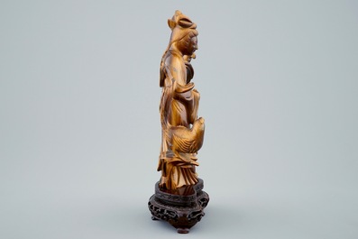 Een Chinese gesculpteerd Guanyin in tijgeroog op houten basis, 19/20e eeuw