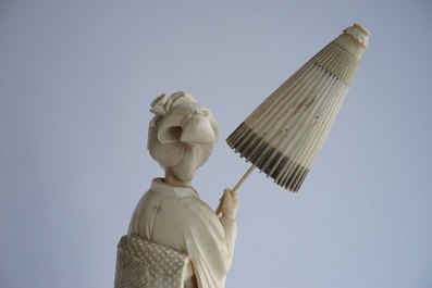 Een Japanse ivoren okimono, dame met parasol, 19e eeuw