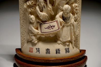 A Chinese carved ivory plaque with immortals on wooden stand, 2nd quarter 20th C.