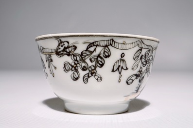 Een Chinese grisaille, vergulde en ijzerrode kop en schotel met romantisch decor, Qianlong
