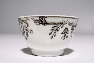 Een Chinese grisaille, vergulde en ijzerrode kop en schotel met romantisch decor, Qianlong