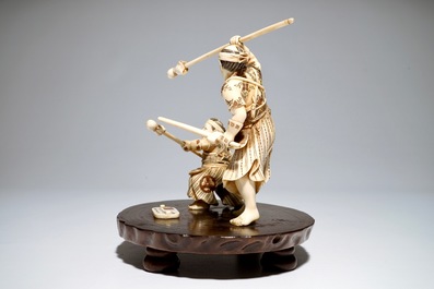 A Japanese ivory group of a warrior and his pupil, on a wooden base, Meiji, signed