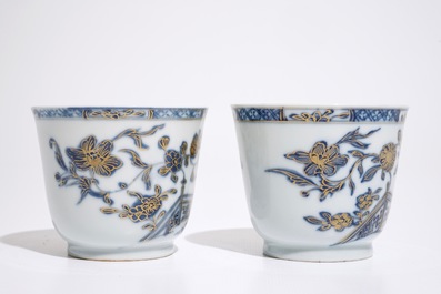 A pair of Chinese blue, white and gilt cups and saucers, Qianlong