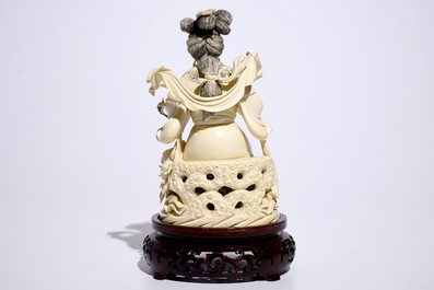 A Chinese ivory figure of a lady playing a flute on wooden base, early 20th C.