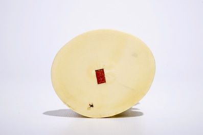 A Japanese ivory okimono of a fisherman on wooden base, Meiji, 19th C., signed