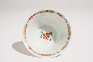 A Chinese famille rose cup and saucer with a tea-drinking scene, Yongzheng