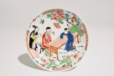 A Chinese famille rose cup and saucer with a tea-drinking scene, Yongzheng