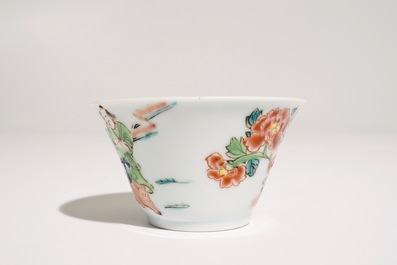A Chinese famille rose cup and saucer with a tea-drinking scene, Yongzheng