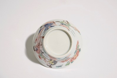 A Chinese famille rose cup and saucer with a tea-drinking scene, Yongzheng