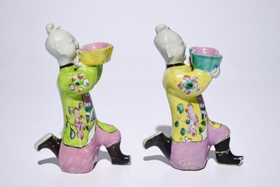 A pair of Chinese famille rose kneeling boy figures, 18/19th C.