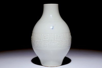 A Chinese monochrome white-glazed olive-shaped vase with underglaze design, Qianlong mark,  19th C.