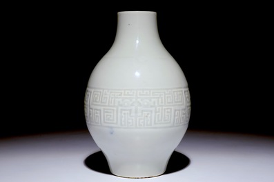 A Chinese monochrome white-glazed olive-shaped vase with underglaze design, Qianlong mark,  19th C.