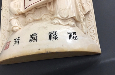 A Chinese carved ivory plaque with immortals on wooden stand, 2nd quarter 20th C.