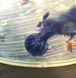 Un bol en porcelaine de Chine bleu, blanc et rouge de cuivre aux carpes et cr&eacute;atures marines, marque et &eacute;poque de Kangxi