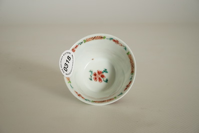 A Chinese famille rose cup and saucer with a tea-drinking scene, Yongzheng