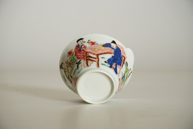 A Chinese famille rose cup and saucer with a tea-drinking scene, Yongzheng