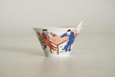 A Chinese famille rose cup and saucer with a tea-drinking scene, Yongzheng