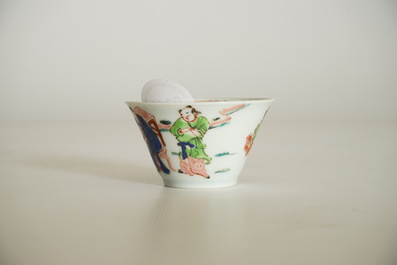 A Chinese famille rose cup and saucer with a tea-drinking scene, Yongzheng