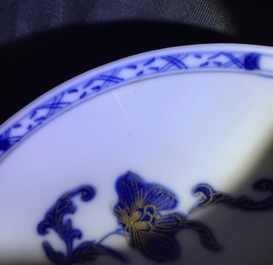 A pair of Chinese blue, white and gilt cups and saucers, Qianlong