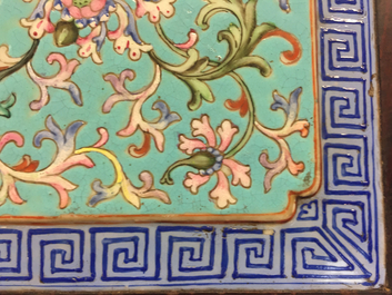 A Chinese famille rose enamel tile plaque mounted in a wood stand, 19th C.