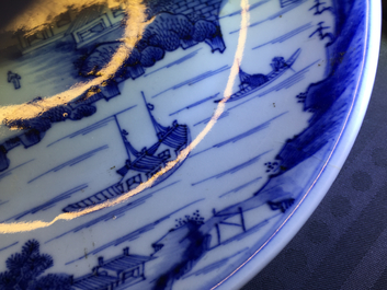Une assiette en porcelaine de Chine bleu et blanc &agrave; d&eacute;cor de paysages, Kangxi, vers 1660