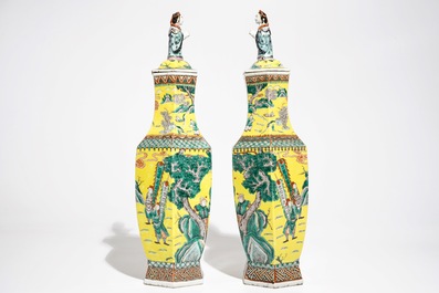 A pair of Chinese hexagonal famille verte yellow-ground vases and covers, 19th C.