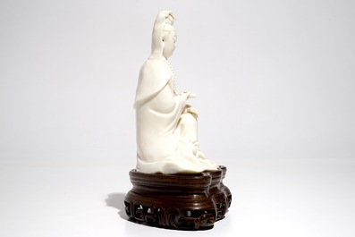 A Chinese Dehua blanc de Chine Guanyin on wooden stand, Kangxi