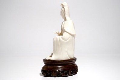 A Chinese Dehua blanc de Chine Guanyin on wooden stand, Kangxi