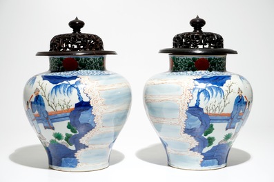 A pair of Chinese wucai baluster vases with carved lids and bases, 19th C.