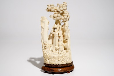 A Chinese ivory group on wooden stand, 2nd quarter 20th C.