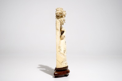 A Chinese ivory group on wooden stand, 2nd quarter 20th C.