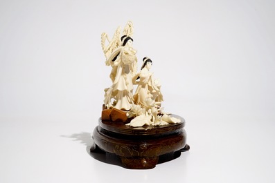 A Chinese carved ivory group of two ladies on wooden base, 2nd quarter 20th C.